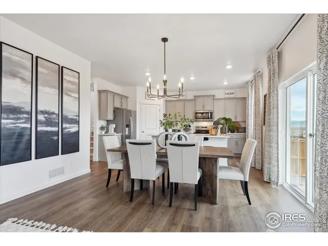 a dining room with furniture a chandelier and wooden floor