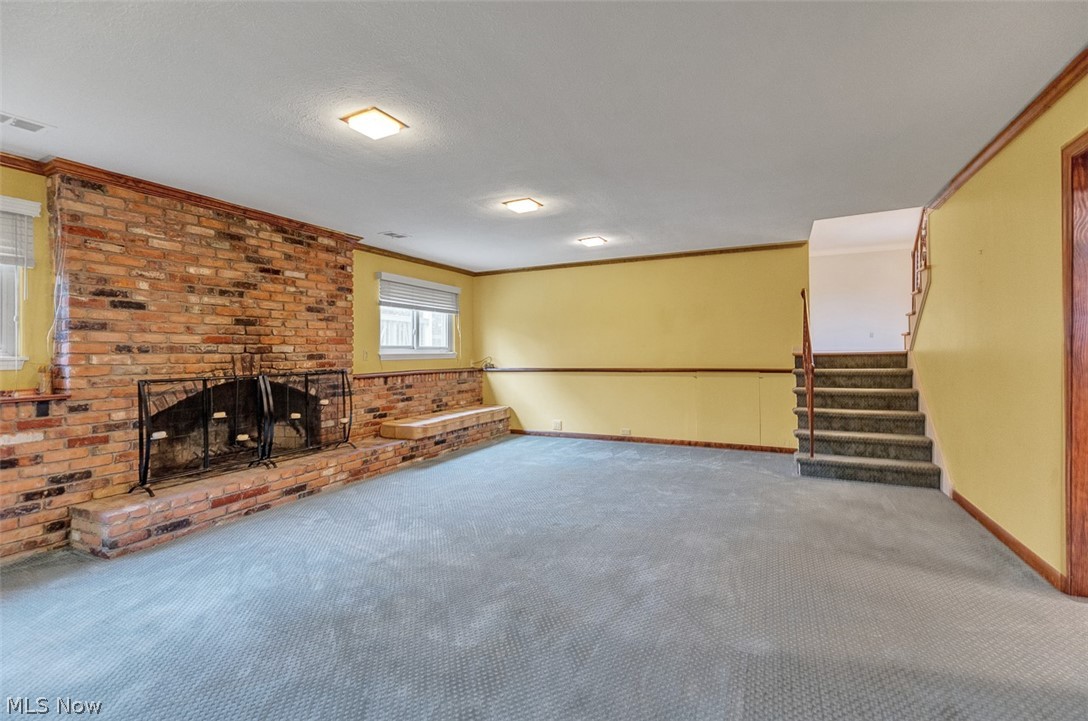 2990 Hampton Road Cleveland, OH 44120 - Photo 19 of 29 Unfurnished living room with crown molding, a fireplace, carpet flooring, and brick wall