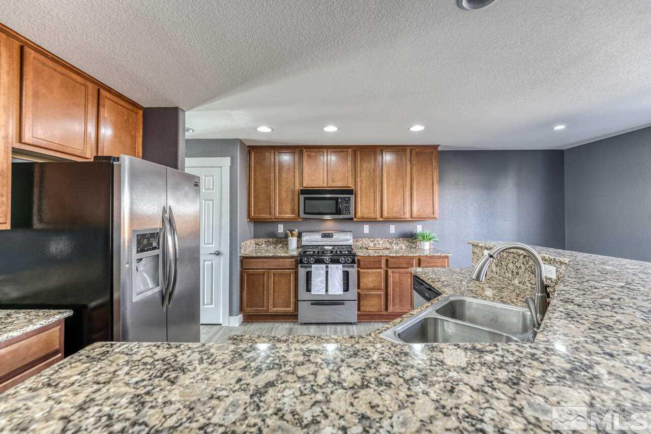 8935 Convair Way Reno, NV 89506 - Photo 14 of 39 a kitchen with granite countertop a refrigerator and a sink