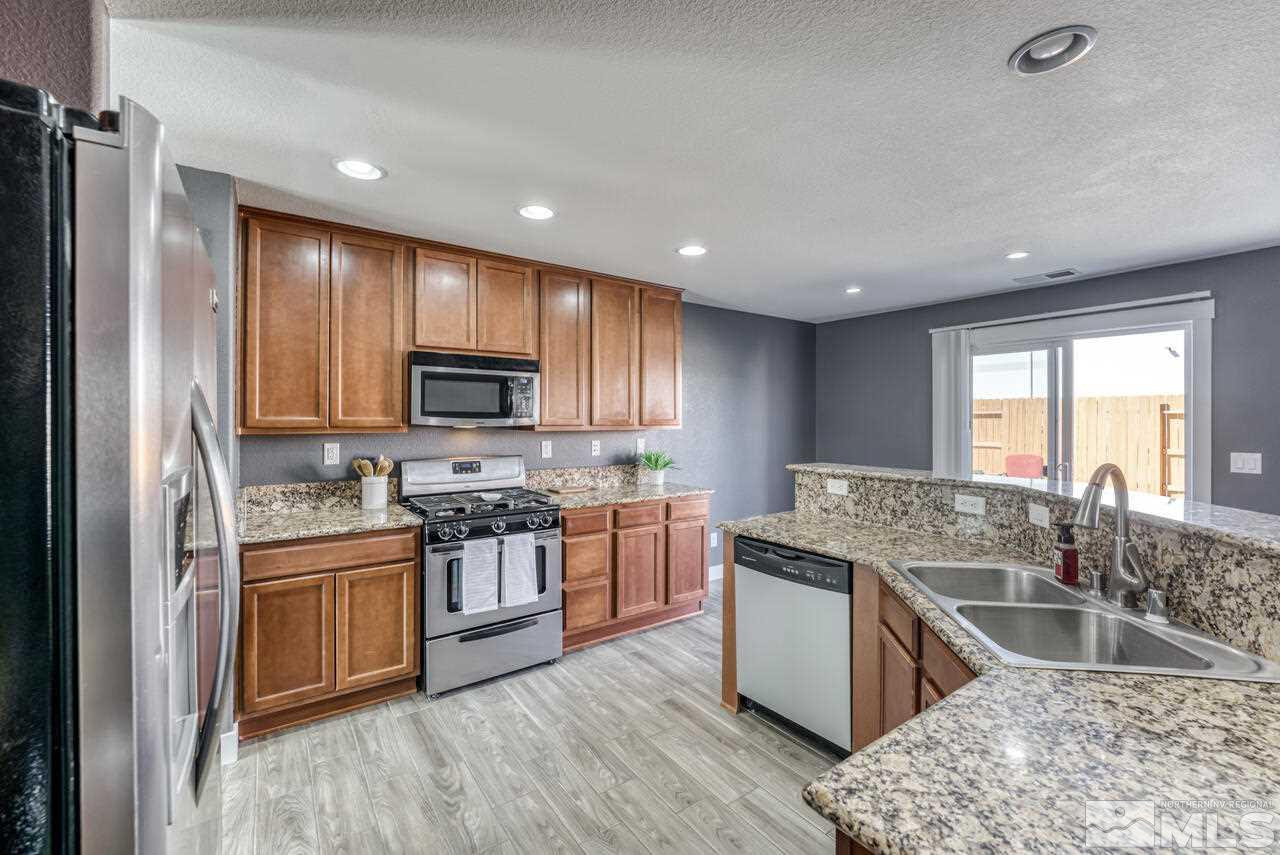8935 Convair Way Reno, NV 89506 - Photo 15 of 39 a kitchen with stainless steel appliances granite countertop a sink stove and refrigerator