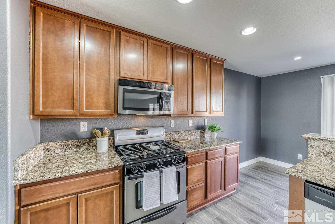 8935 Convair Way Reno, NV 89506 - Photo 16 of 39 a kitchen with granite countertop wooden cabinets and stainless steel appliances