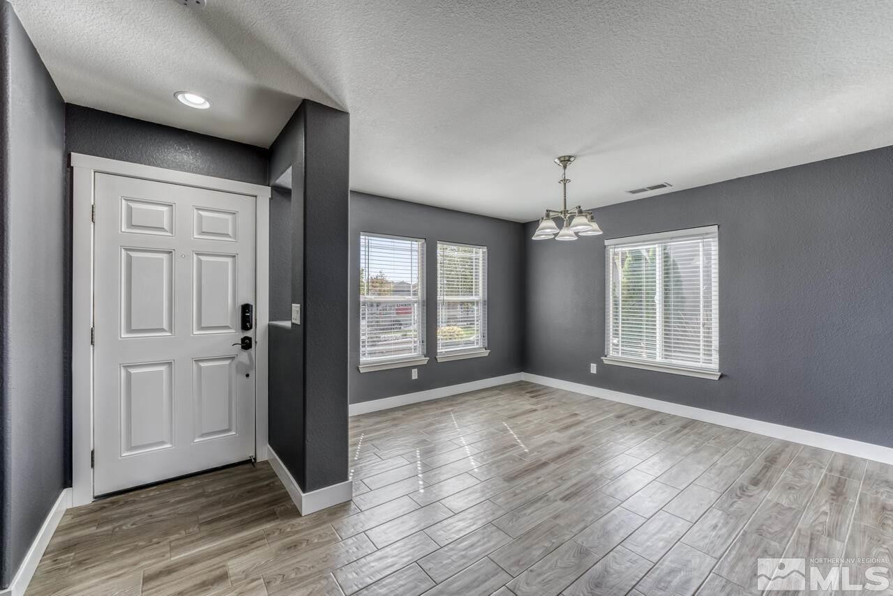8935 Convair Way Reno, NV 89506 - Photo 5 of 39 an empty room with wooden floor and windows