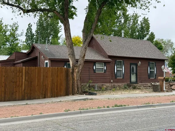 a house that has a tree in front of it