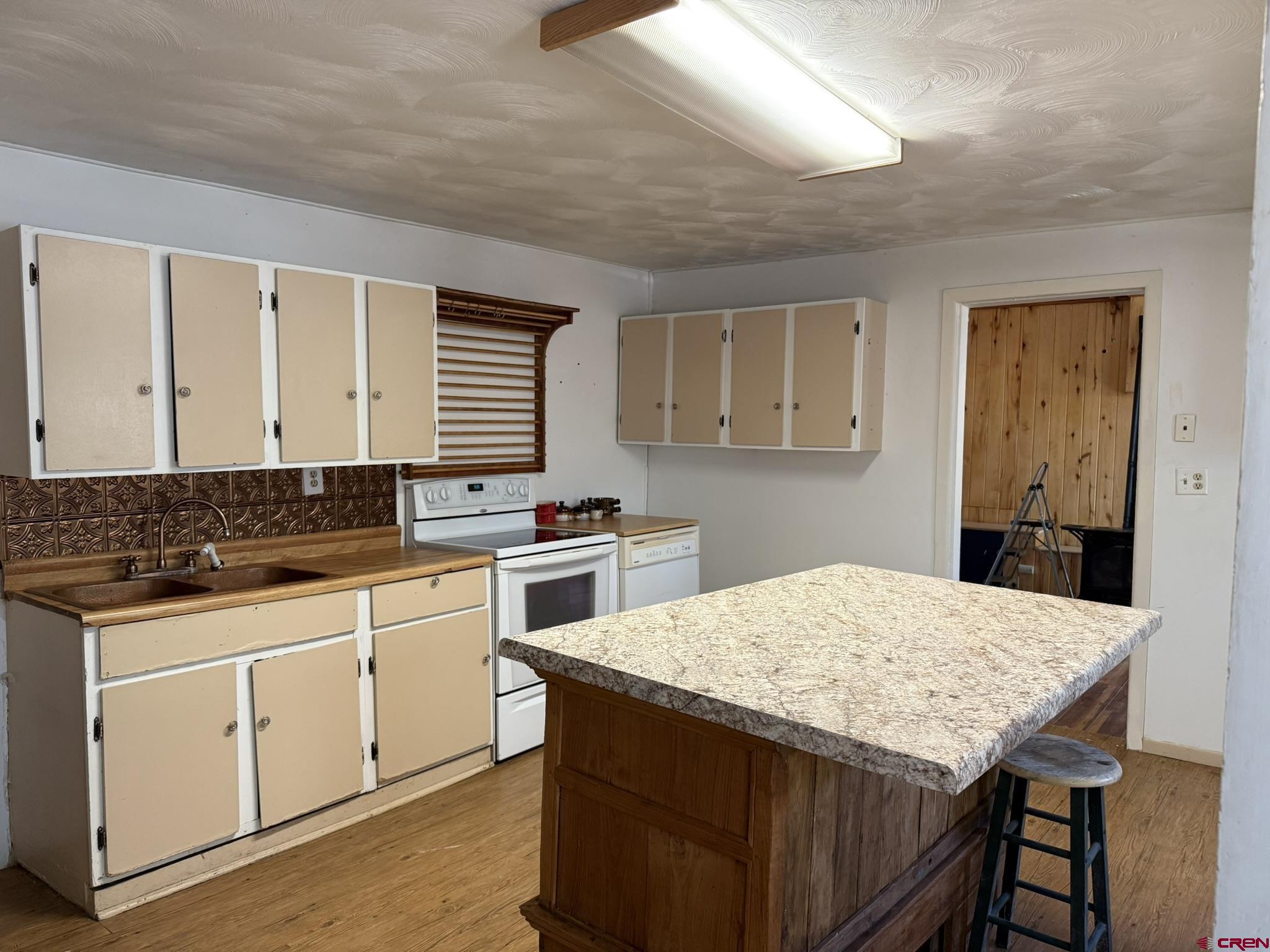 311 West 3rd Street Delta, CO 81416 - Photo 9 of 24 a kitchen with granite countertop a sink white cabinets and white appliances