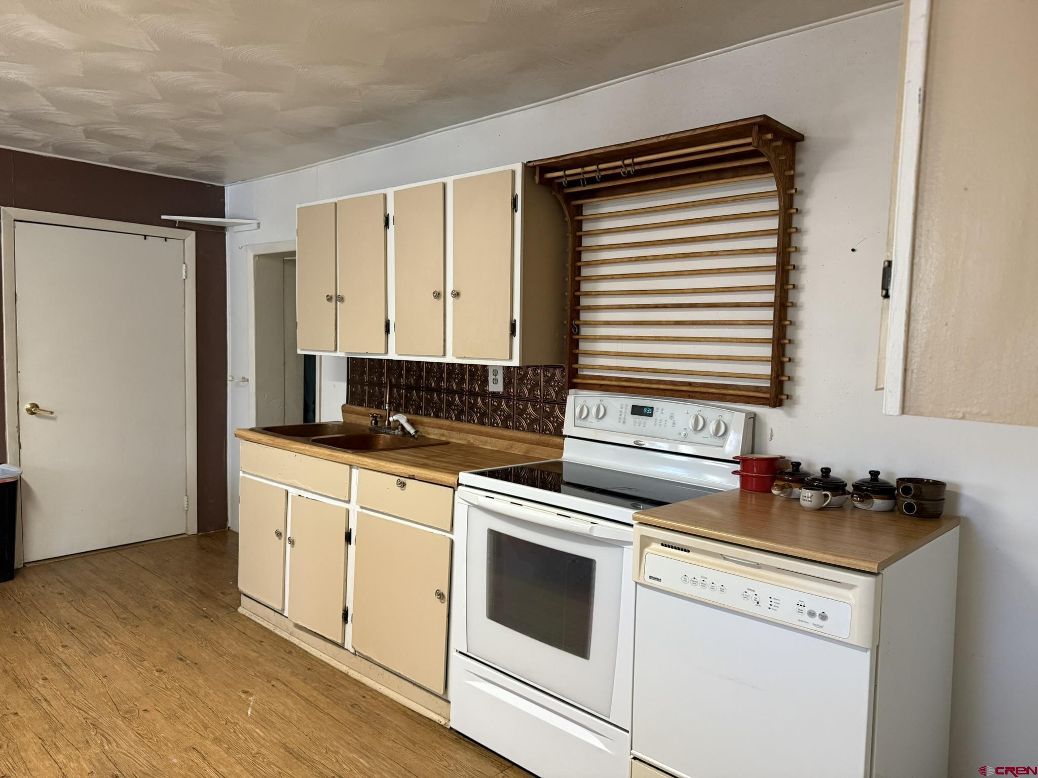 311 West 3rd Street Delta, CO 81416 - Photo 10 of 24 a kitchen with granite countertop white cabinets and white appliances