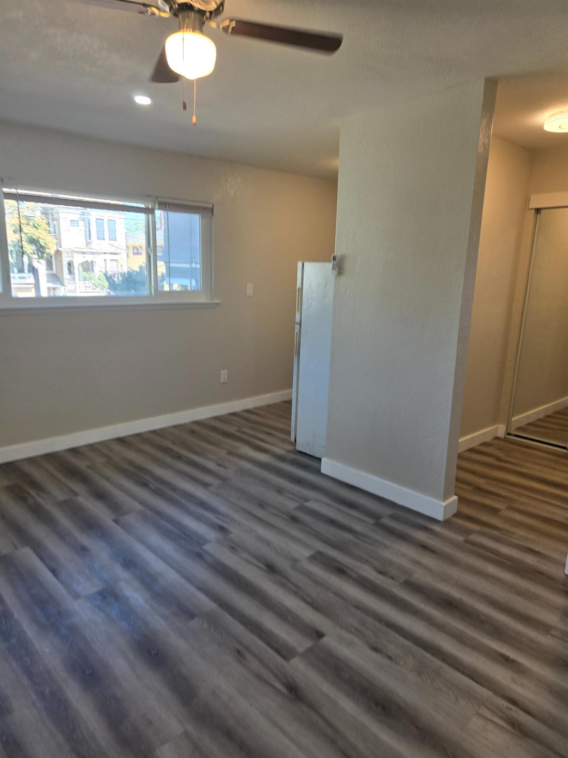 1036 North Sutter Street, Unit 4 Stockton, CA 95202 - Photo 2 of 5 an empty room with wooden floor and windows