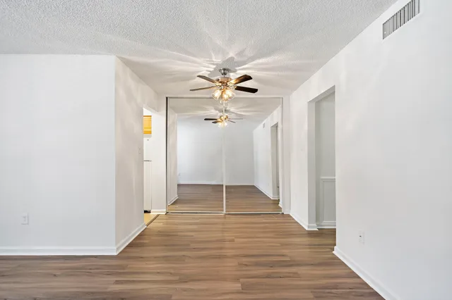 a view of an empty room with wooden floor