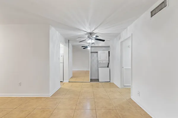 an empty room with closet and ceiling fan