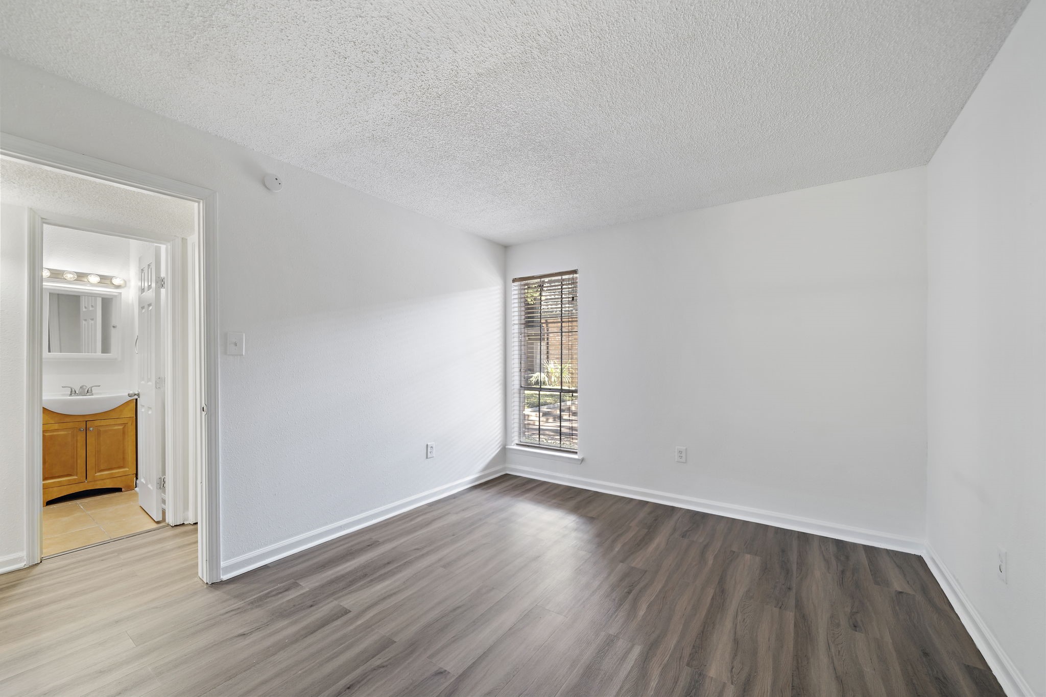 711 Holiday Drive, Unit 33 Galveston, TX 77550 - Photo 6 of 10 an empty room with wooden floor and windows
