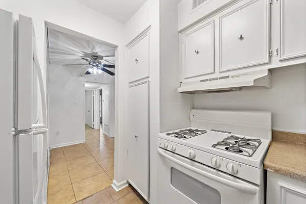 a kitchen with white cabinets and white appliances