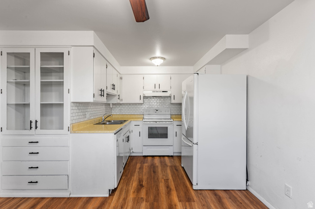 728 400 East Orem, UT 84097 - Photo 9 of 30 Kitchen featuring white cabinetry with black hardware, glass-front upper cabinets, light yellow countertops, and a subway tile backsplash