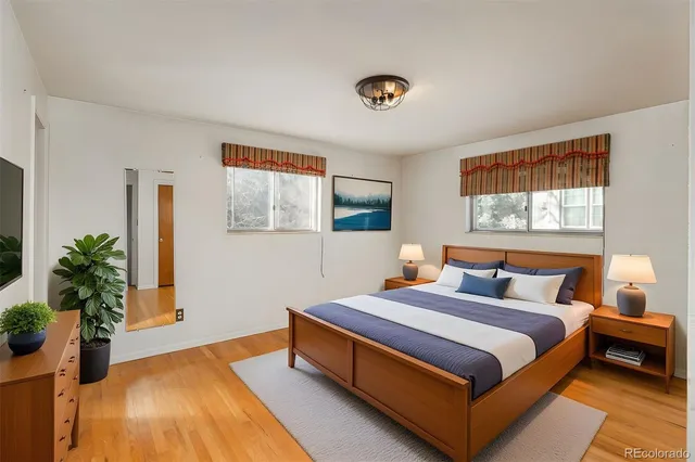 a spacious bedroom with a bed and a potted plant