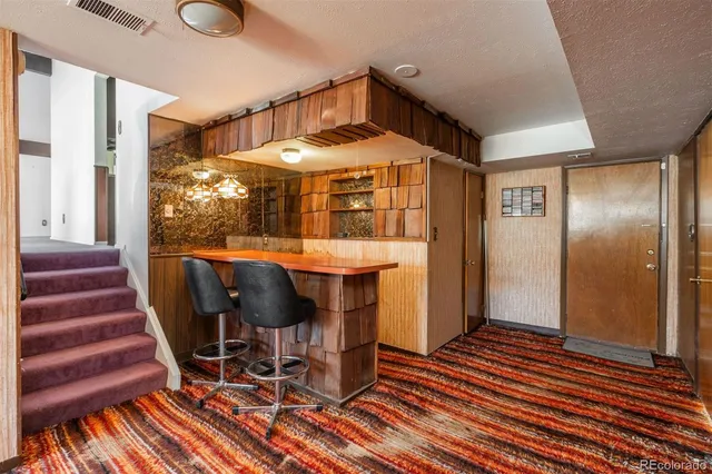 a view of a hallway with wooden floor and furniture