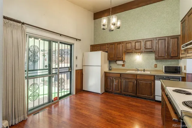 a kitchen with granite countertop wooden floors a stove and a refrigerator