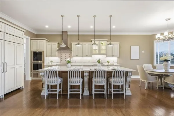 a kitchen with stainless steel appliances granite countertop a sink a stove and chairs