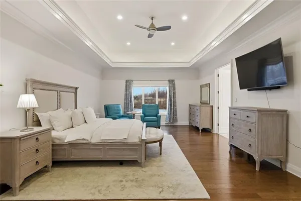 a spacious bedroom with a bed a couch and dresser