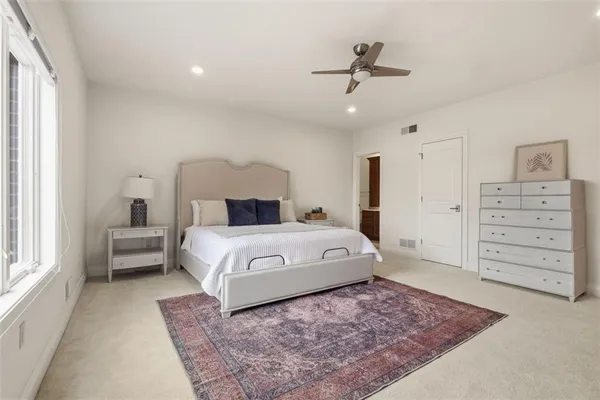 a bedroom with a large bed and a flat tv screen on dresser