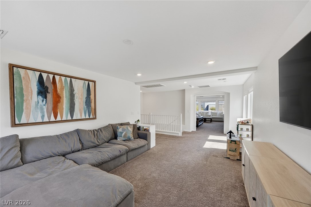 10446 Emerald Rye Street Las Vegas, NV 89183 - Photo 19 of 37 A generously sized living space with neutral carpet flows seamlessly to additional areas, perfect for daily living.