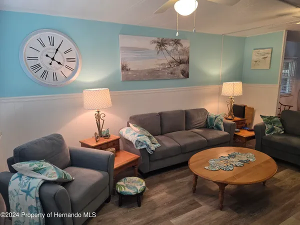 a living room with furniture a rug and a wall painting