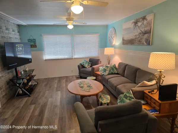 a dining room with furniture potted plants and wooden floor