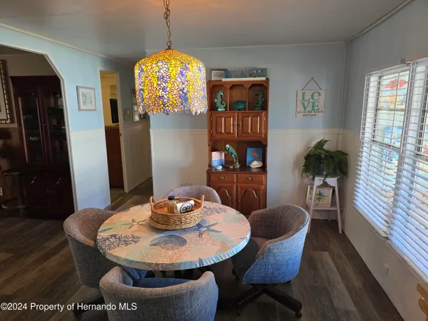 a dining room with furniture a chandelier and wooden floor