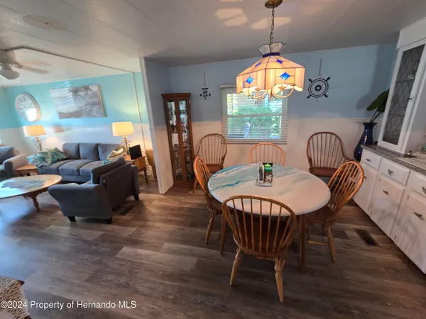 a dining room with furniture a chandelier and wooden floor