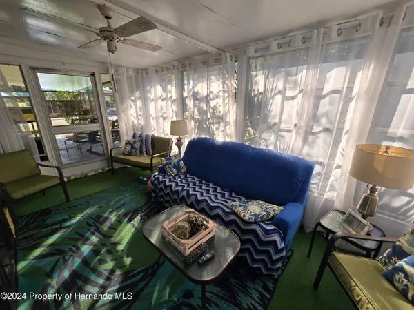 a living room with furniture and a floor to ceiling window