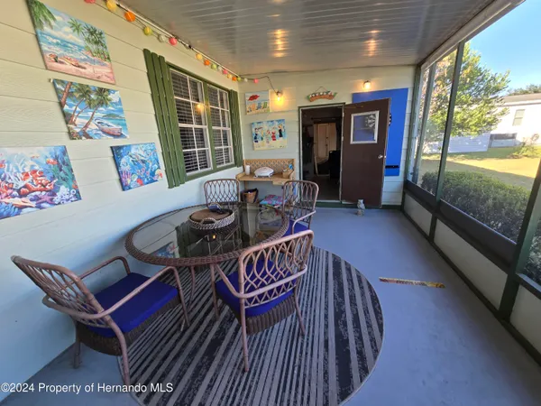 a living room with furniture gym equipment and large windows
