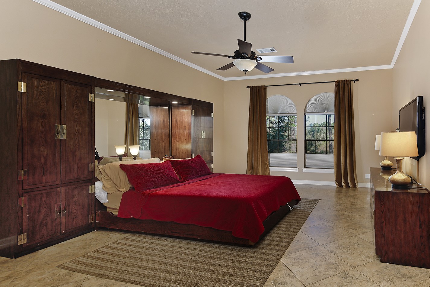 24635 West Kingscrest Circle Spring, TX 77389 - Photo 20 of 38 a bedroom with a large bed and a chandelier