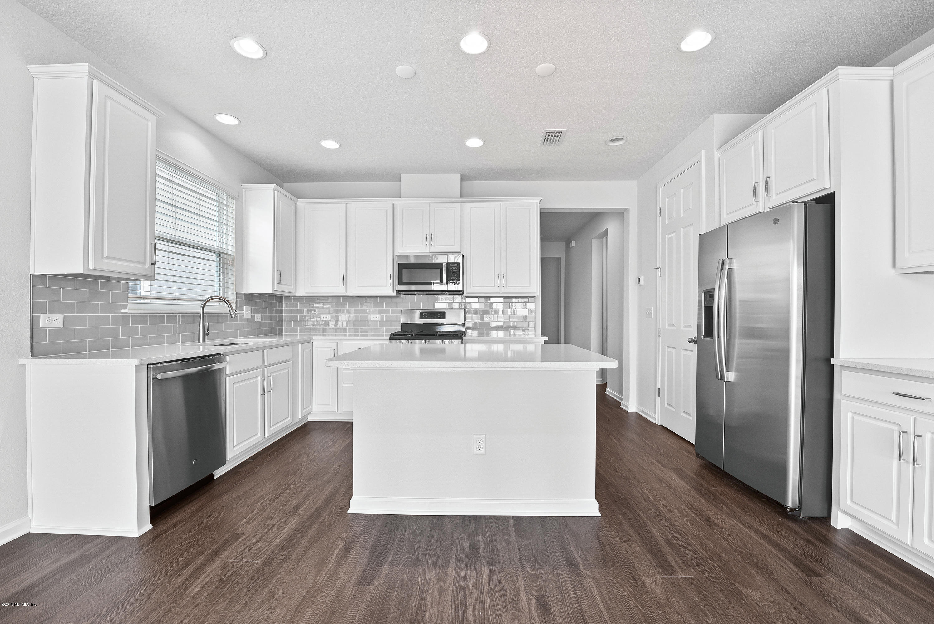6625 Azalea Park Road Jacksonville, FL 32259 - Photo 8 of 26 a kitchen with stainless steel appliances granite countertop a refrigerator a sink dishwasher a stove and white countertops with wooden floor