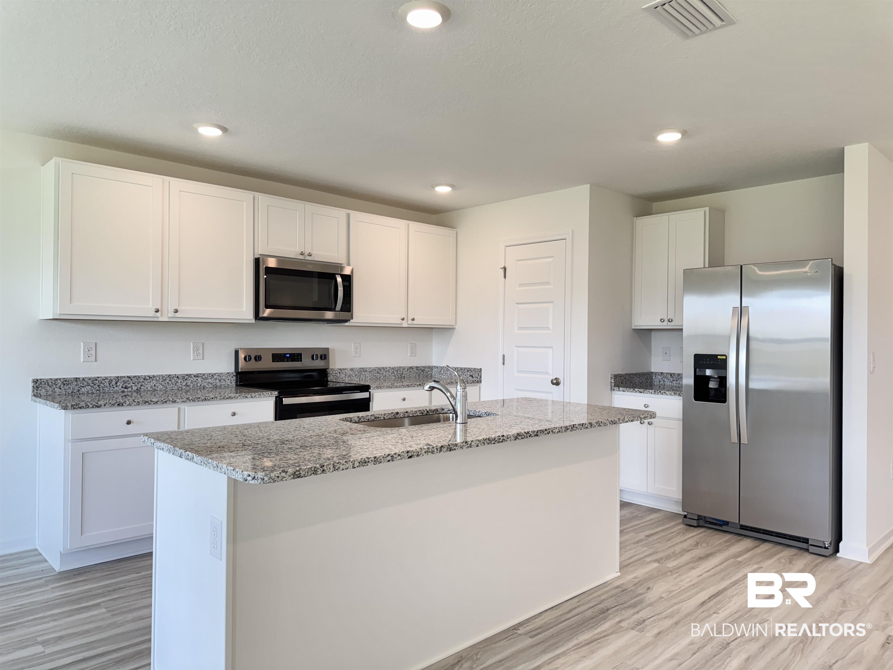 22072 Aleutian Avenue Foley, AL 36535 - Photo 4 of 47 Kitchen with stainless steel appliances, light vinyl plank flooring, white cabinets, granite countertops and recessed lighting. All appliances are brand new with a manufacture warranty.