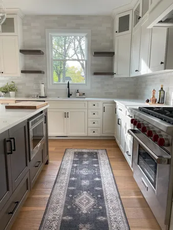 a large kitchen with stainless steel appliances granite countertop a stove a sink dishwasher and cabinets with wooden floor