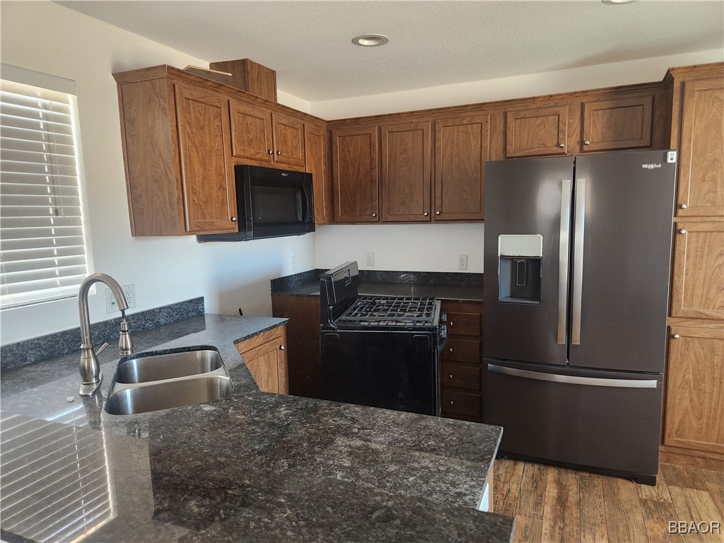 60784 Stagemans Road Landers, CA 92285 - Photo 3 of 9 a kitchen with granite countertop a refrigerator stove and microwave