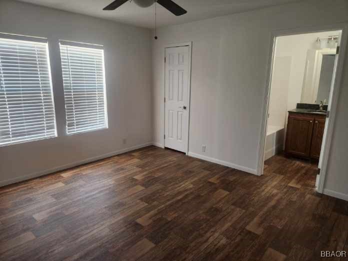 60784 Stagemans Road Landers, CA 92285 - Photo 9 of 9 an empty room with wooden floor a ceiling fan and windows