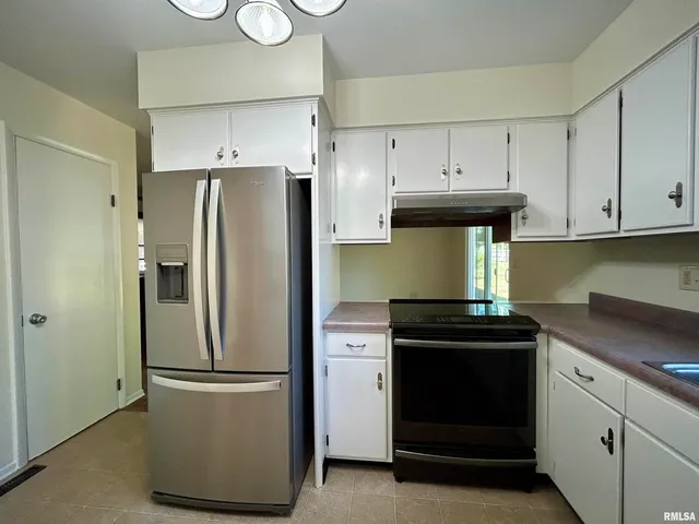 a kitchen with a refrigerator and a stove