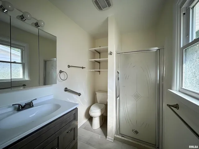 a bathroom with a granite countertop sink toilet and shower