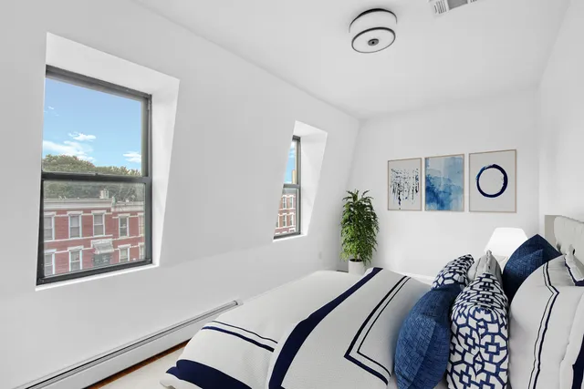 a bed sitting in a bedroom next to a window