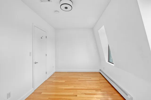 a view of a room with wooden floor and white walls