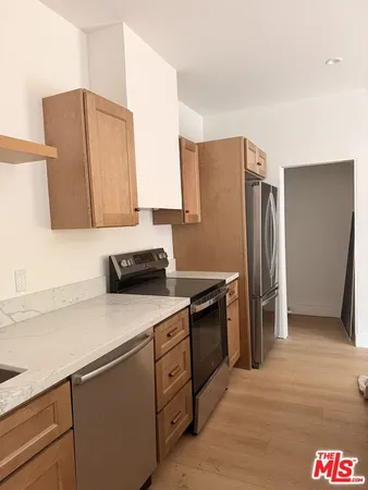 a kitchen with stainless steel appliances granite countertop a refrigerator and a sink