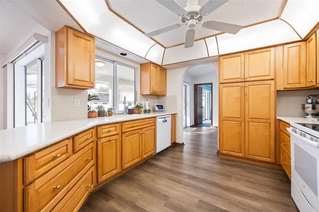a large kitchen with stainless steel appliances granite countertop a lot of counter space and wooden floors