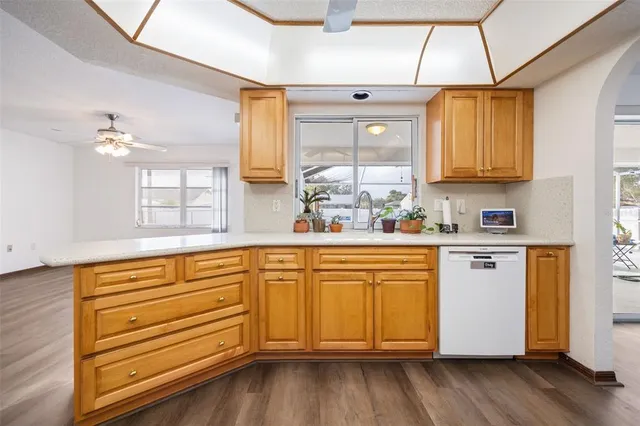 a kitchen with stainless steel appliances granite countertop a sink window and cabinets
