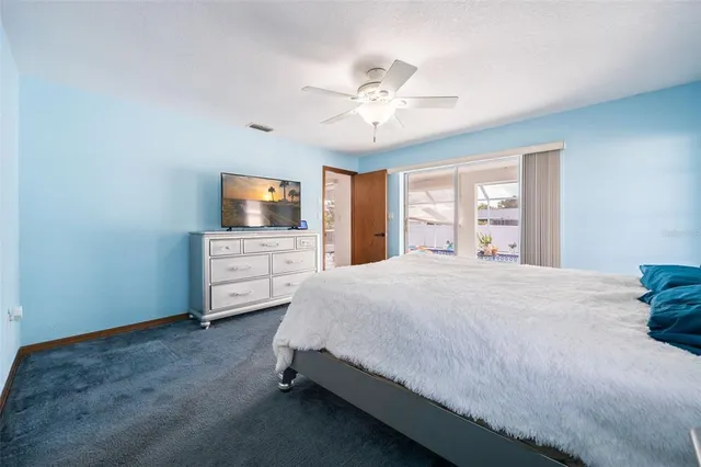 a spacious bedroom with a bed and a flat screen tv
