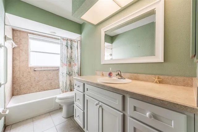 a bathroom with a granite countertop sink toilet a large mirror and a bathtub
