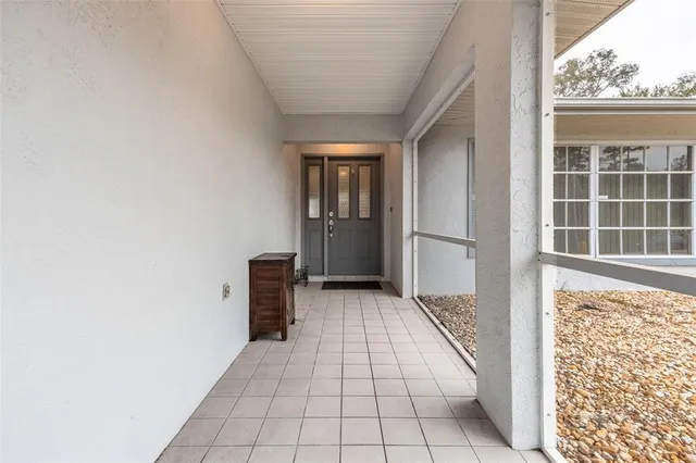 a view of a hallway with wooden floor and a window