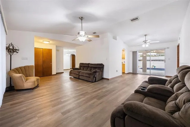a living room with furniture and a wooden floor