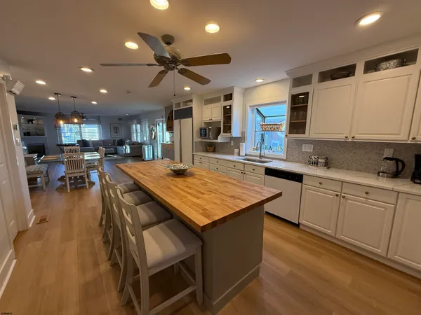 a kitchen with stainless steel appliances granite countertop table chairs sink and cabinets