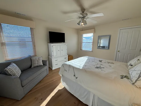 a spacious bedroom with a bed a couch and a flat screen tv