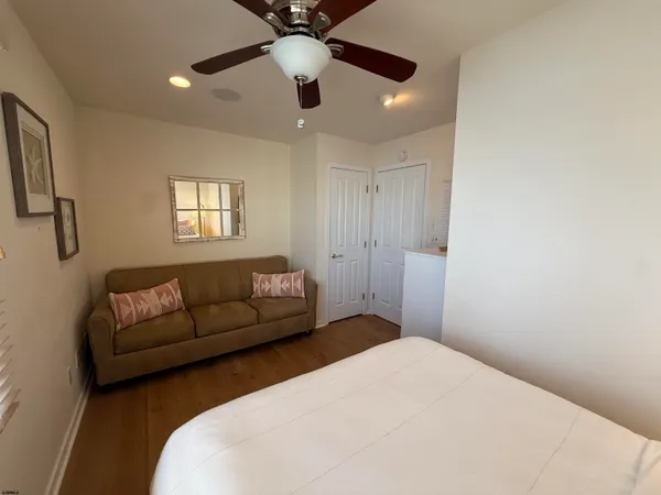 a bedroom with a bed ceiling fan and a window