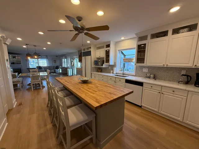 a kitchen with stainless steel appliances granite countertop table chairs sink and cabinets
