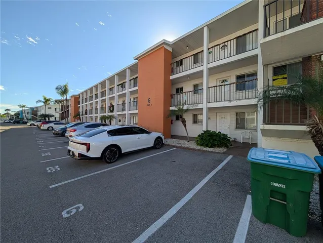 a view of building with cars parked in front of it